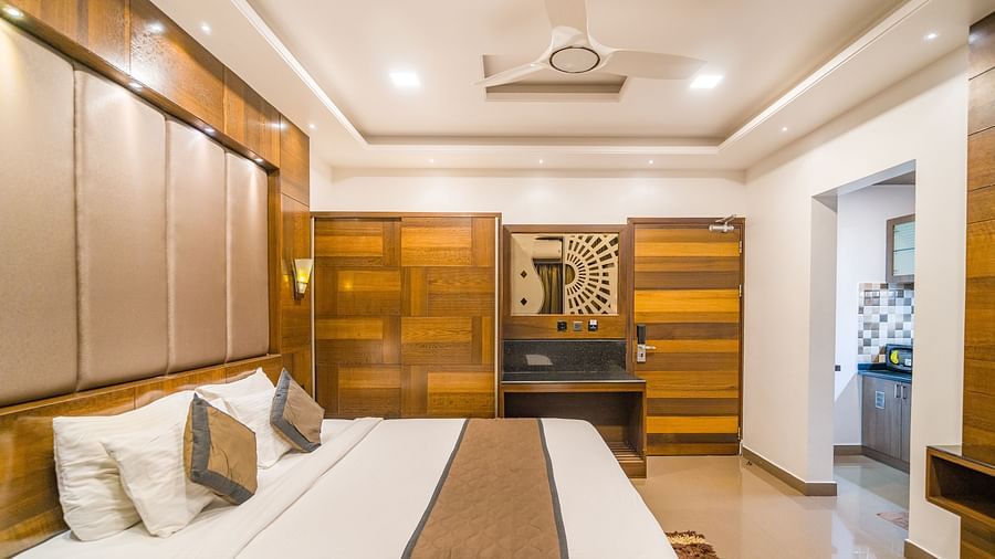 Side view of a room with a bed and a ceiling fan above the bed at Hotel Altitude, Madikeri.